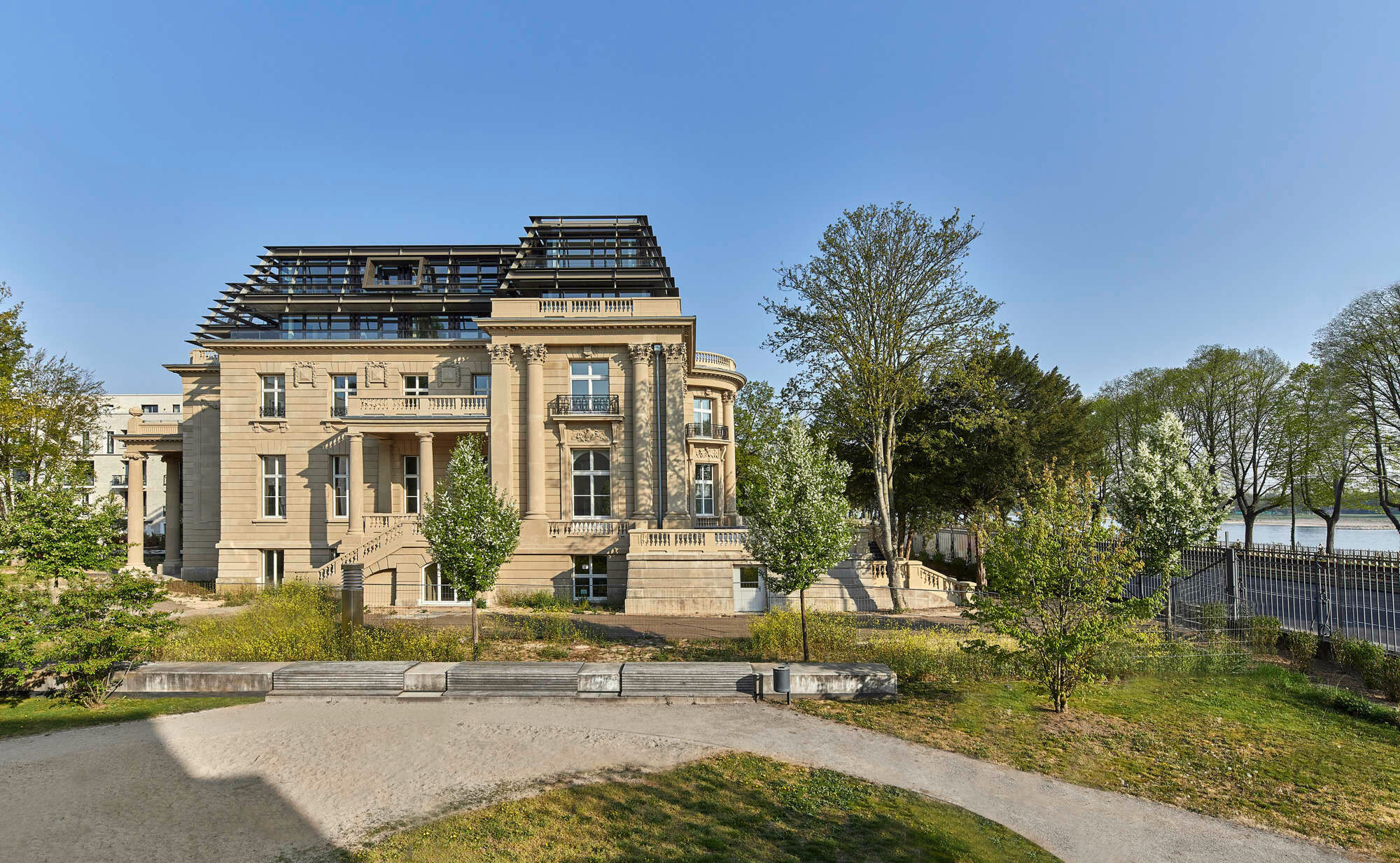 Die Lamellenfassade der Aufstockung zeichnet das frühere Mansarddach nach.
