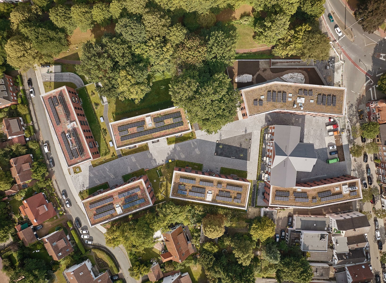 Der Entwurf von Schönborn Schmitz Architekten sieht sechs annähernd baugleiche, dreigeschossige Quader mit roter Ziegelhülle vor, die locker um das Stiftsgebäude gruppiert sind.