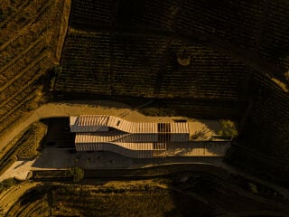 Das Bauwerk besteht aus parallel angeordneten Riegeln, die zueinander verschoben und durch eine gewundene Dachkonstruktion verknüpft sind.