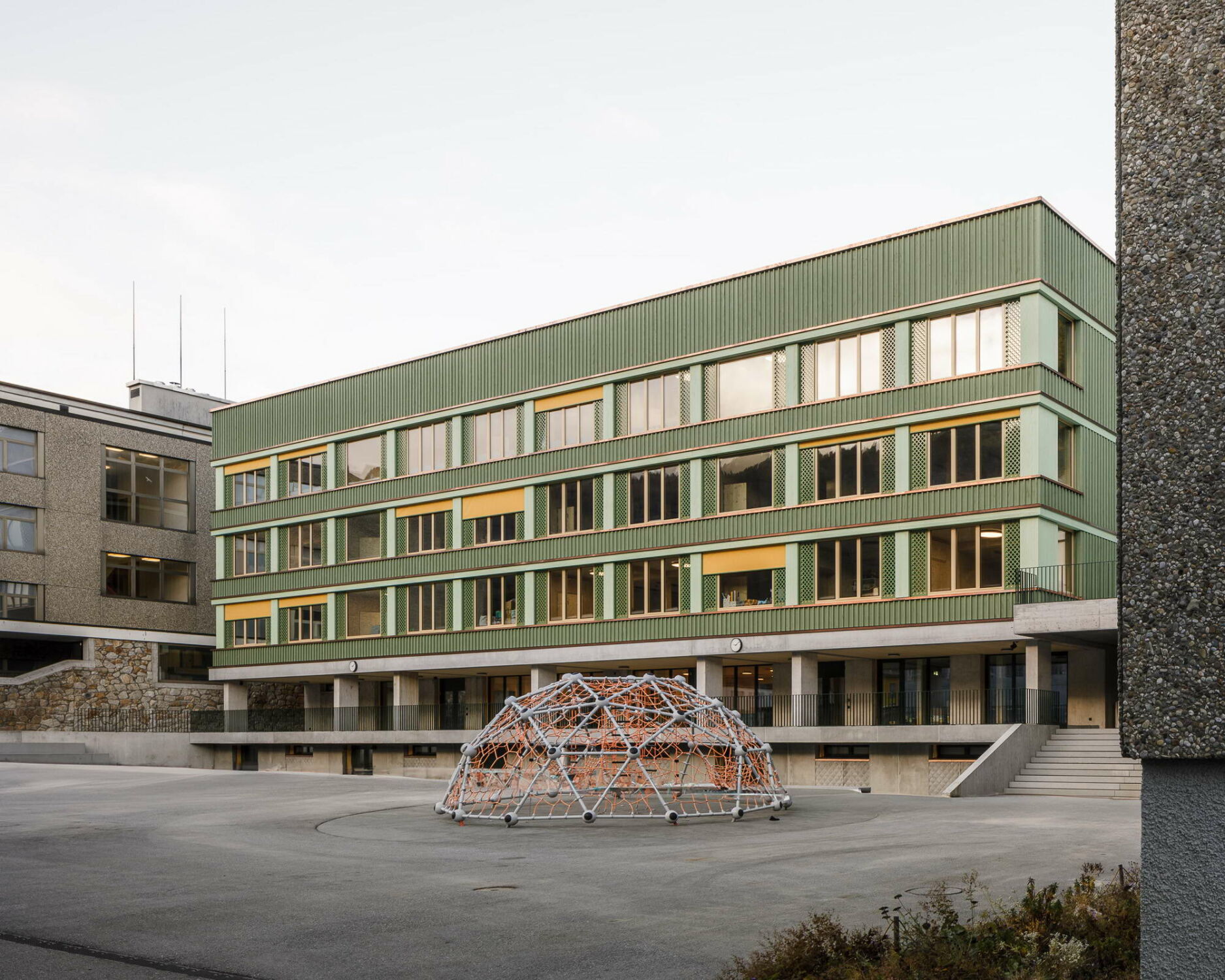 Das Erdgeschoss ist zum Schulhof orientiert, während die Obergeschosse mit den Klassenräumen nach innen zum zentralen Atrium ausgerichtet sind.