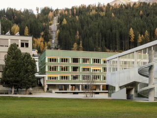 Über den Bestandsbau des Schulzentrums in Davos Platz aus den 1960er-Jahren wurde ein Neubau aus Holz gestülpt.