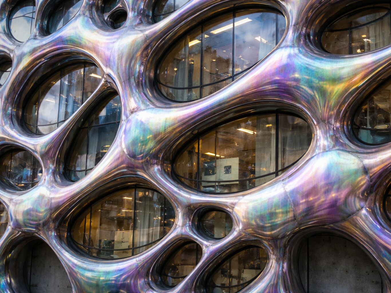 Eine amorphe Fassade aus irisierendem Metall wäre aufwendig im Rendering, dauert aber nur zehn Sekunden mit der KI. Das erhöht die Zahl der Variationen und die Geschwindigkeit im Prozess. Doch was diente als Vorlage und wem gehören die erzeugten Daten?