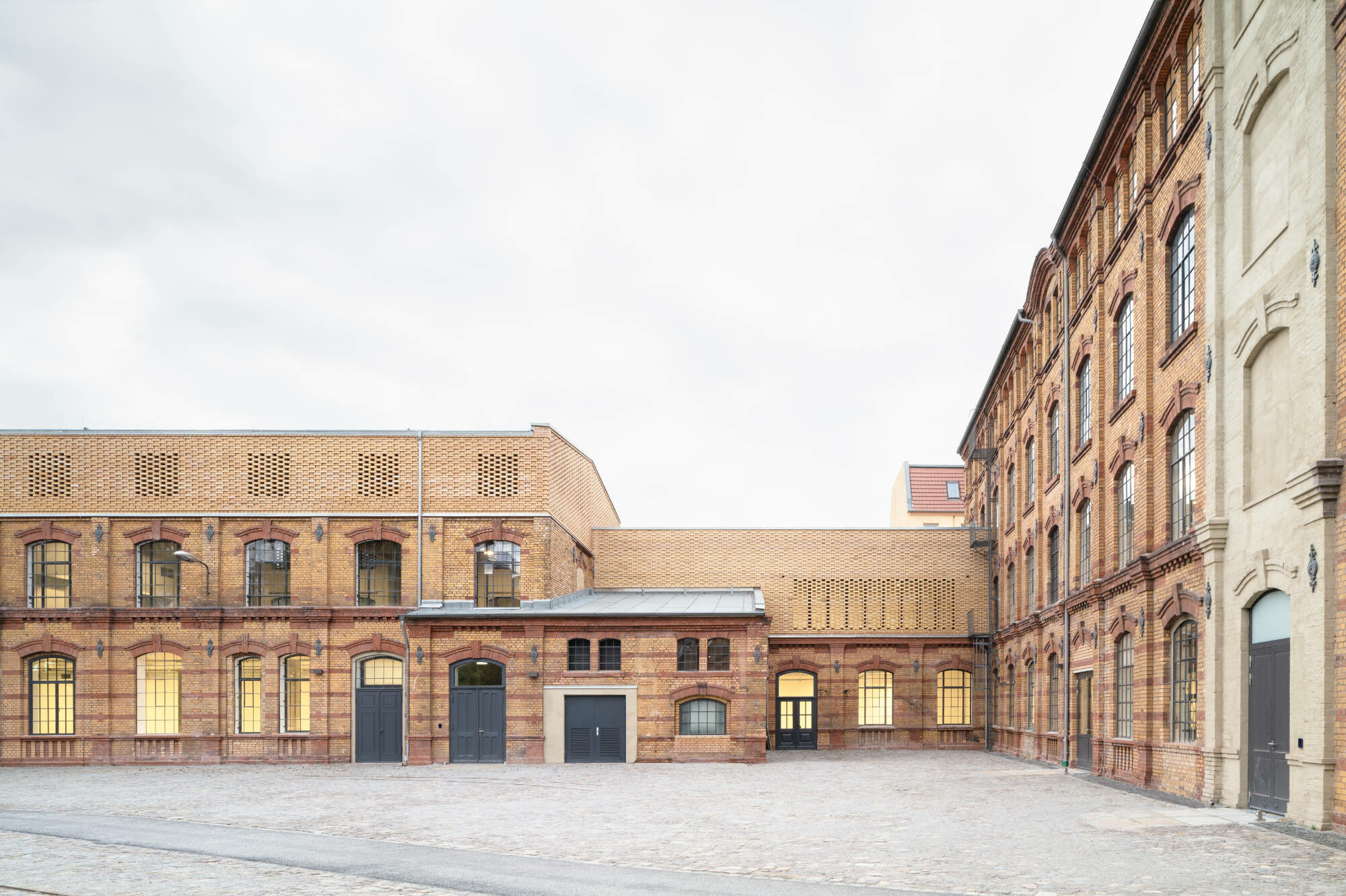 Neubauteile schließen im Krieg entstandene Lücken und stellen die historische Hofsituation des Industrieensembles wieder her.