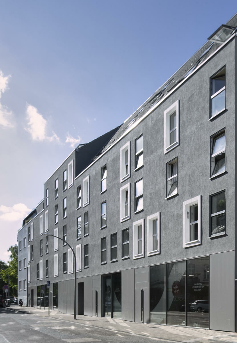 Durch Staffelungen und eine differenzierte Anordnung der Fensteröffnungen wird die große Baumasse kleinteilig gegliedert. 