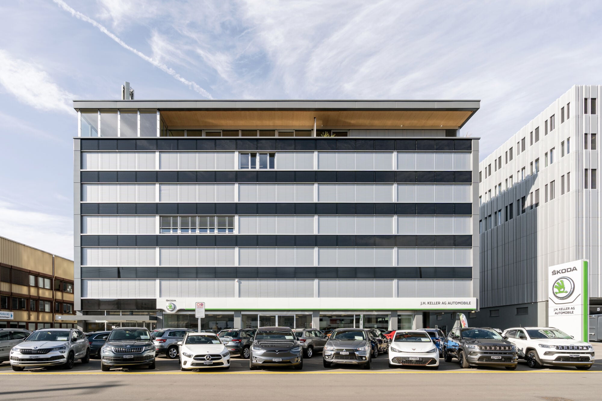 Zur Straße hin liegt der siebengeschossige Kopfbau mit Präsentations- und Büroflächen sowie einer Wohnung im Attikageschoss.