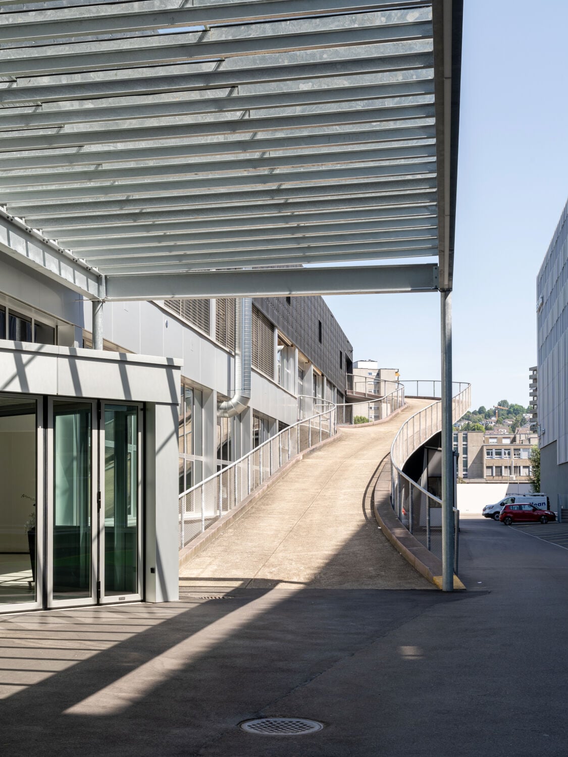 Eine bauzeitliche Rampe erschließt die dreigeschossige Halle. Die Überdachung der Werkstattzufahrt wurde erneuert. 