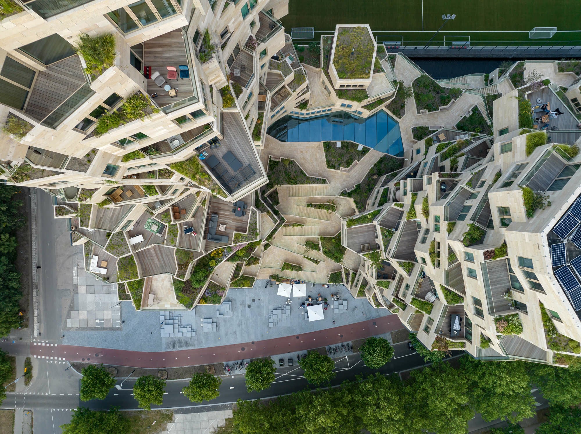 In der Mitte zerschneidet eine öffentlich zugängliches Terrasse den Komplex, bildet ein ansteigendes Tal. Darunter, erhellt von einem Oberlicht, liegt grottenähnlich ein öffentliches Atrium.