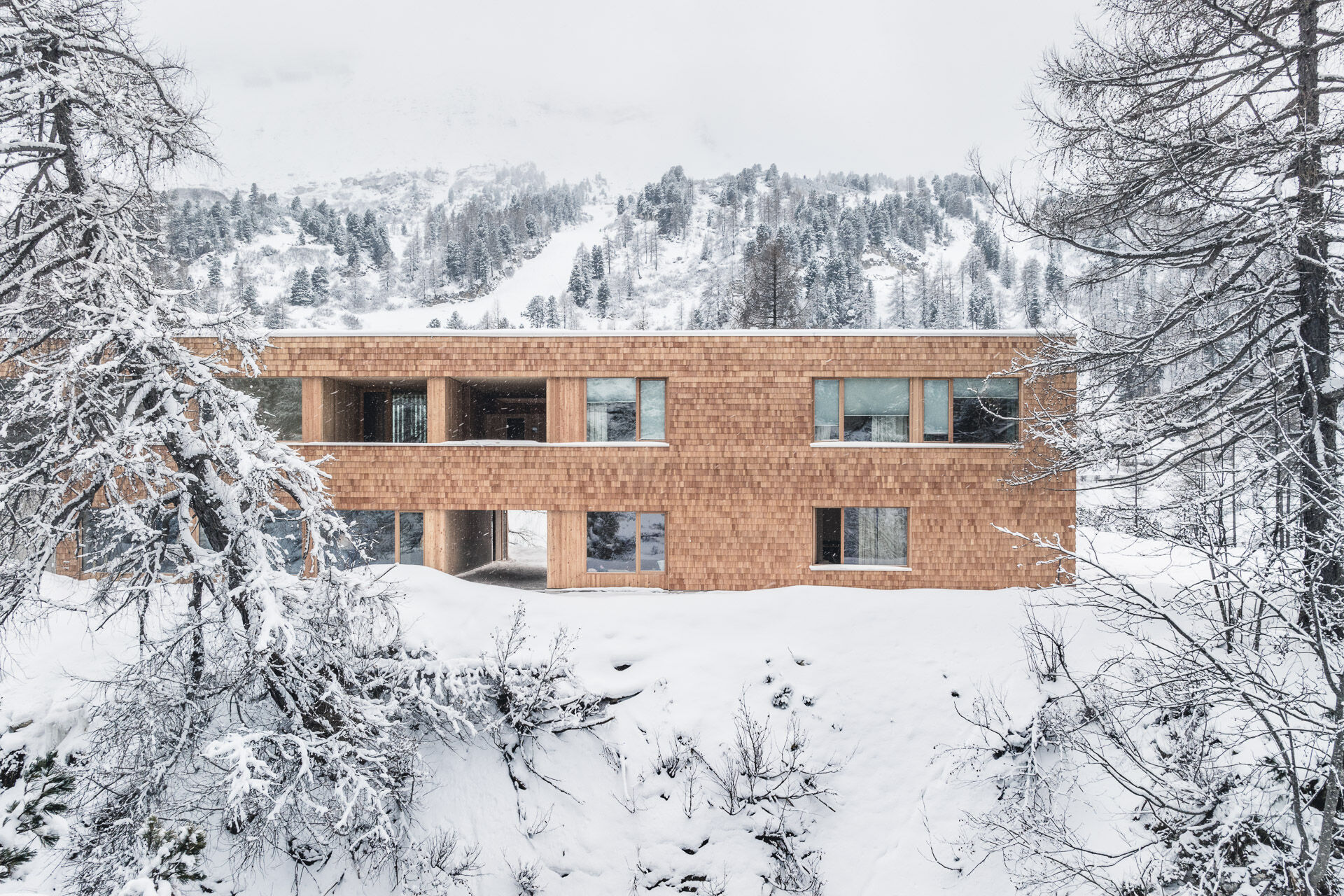 Die Fassade aus Lärchenholzschindeln bewirkt eine gute Einbindung in die Landschaft.