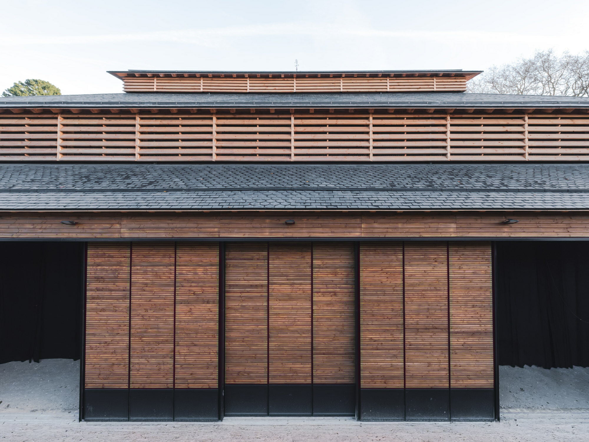 In einem von zwei Höfen der historischen Anlage planten K Architectures Sigwalt Herman eine neue Reithalle, deren Pyramidendach die Silhouette der alten Stallungen krönt.