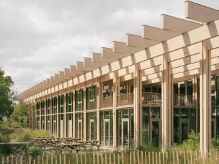 Der zweigeschossige, pavillonartige Neubau in Holzhybridbauweise gliedert sich harmonisch in die Parklandschaft ein.