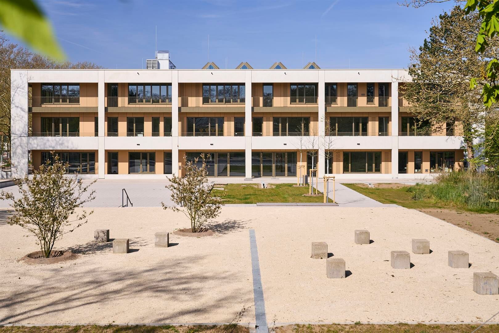 Ein großzügiger Schulhof vor dem neuen Hauptgebäude leitet die Schüler*innen und Lehrende ins Innere.