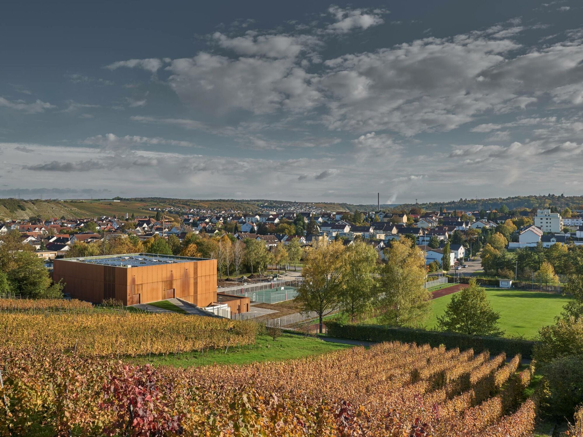 Die Fassade aus Cortenstahl und die begrünten Dachflächen schaffen eine Verbindung zur Landschaft.
