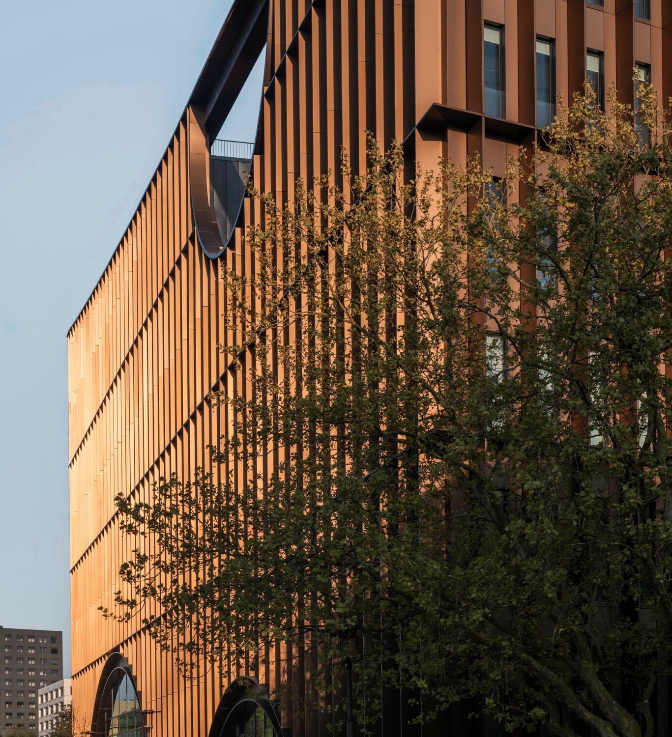 Die bronzefarbenen vertikalen und horizontalen Aluminiumelemente der Fassade erzeugen, je nach Lichteinstrahlung, eine Art kinetischen Effekt.