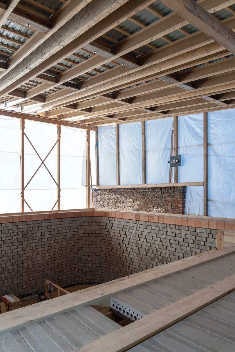 HLCB: Einblick Baustelle Neubau mit Lehmsteinmauerwerk und Geschossdecke aus BSH-Balken und Lehmeinhangsteinen