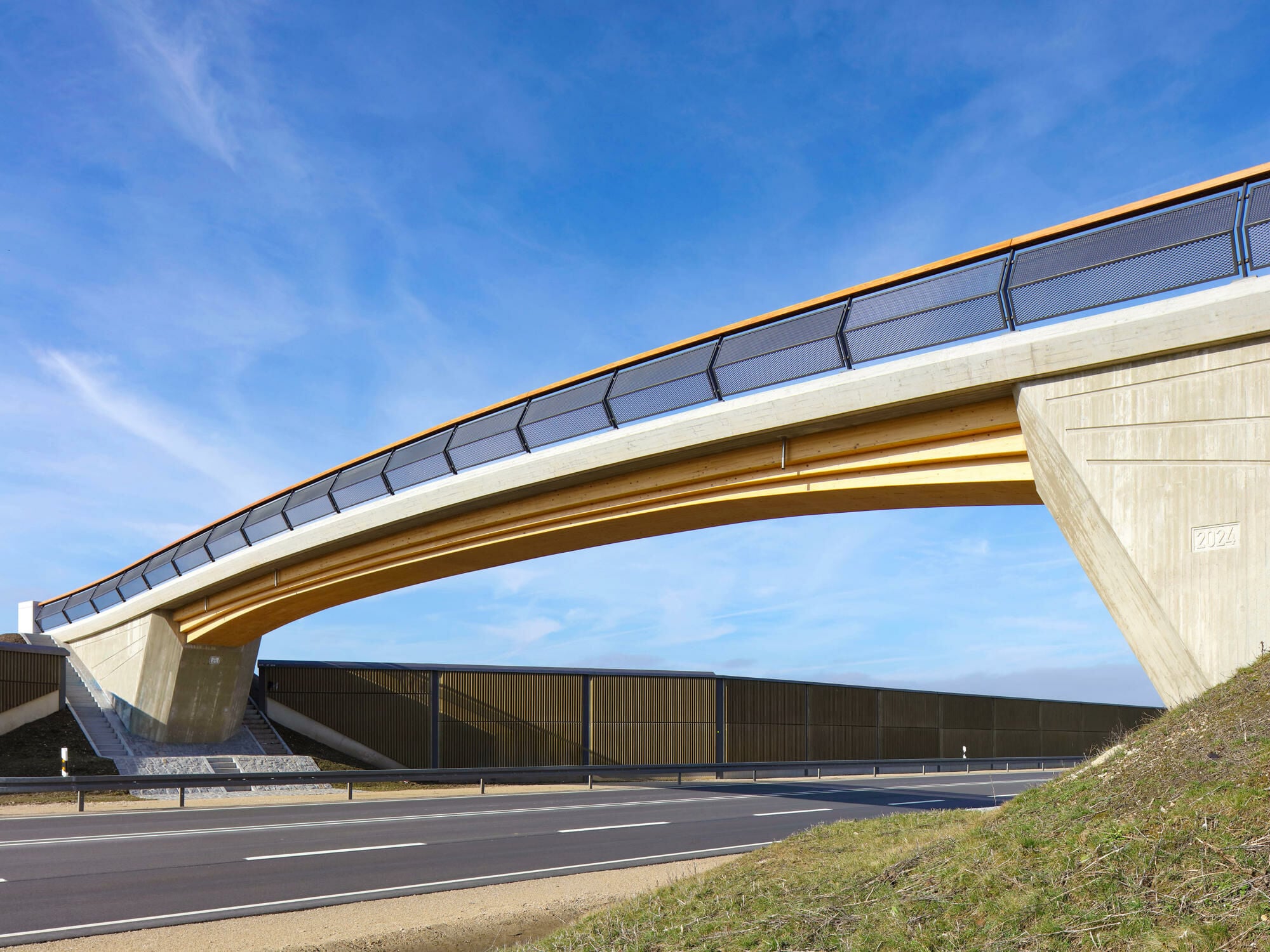 Das Ingenieurbüro Miebach aus Lohmar plante eine integrale Holz-Beton-Verbundbrücke. Seit 2025 überspannt sie die Bundesstraße B16 bei Ingolstadt.