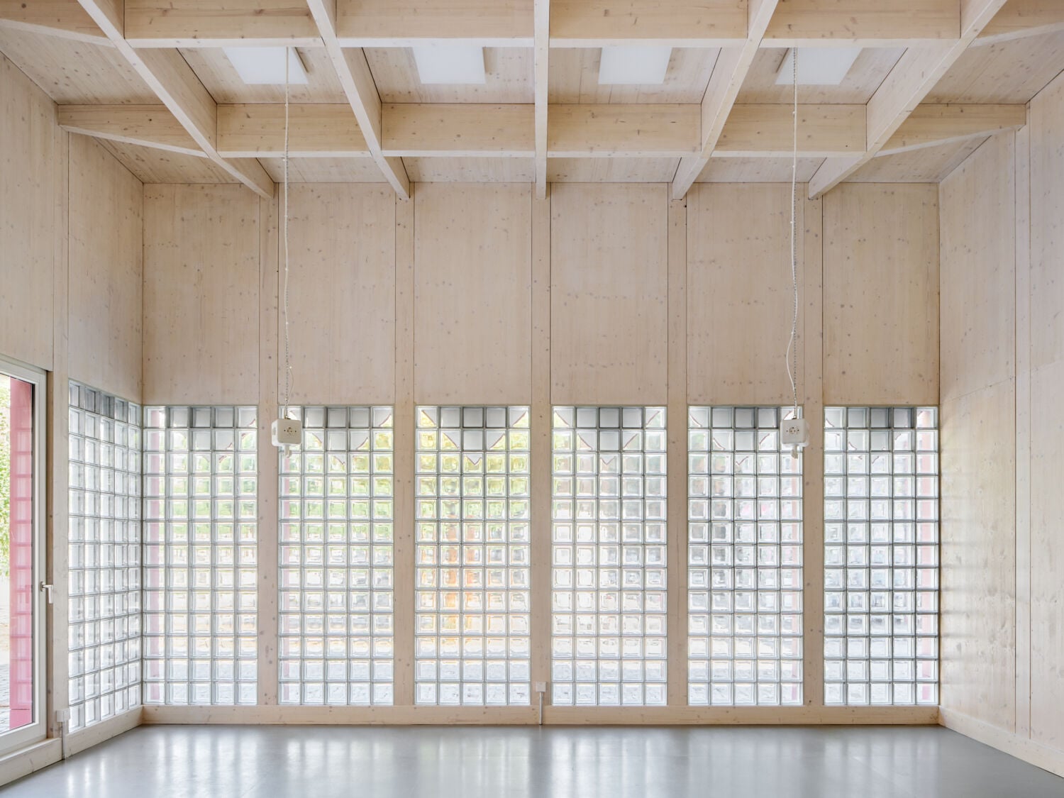 Die Holzwerkstatt nach Plänen von Bachmann Badie Architekten zieht mit einer dekorativen roten Fassade die Blicke auf sich.