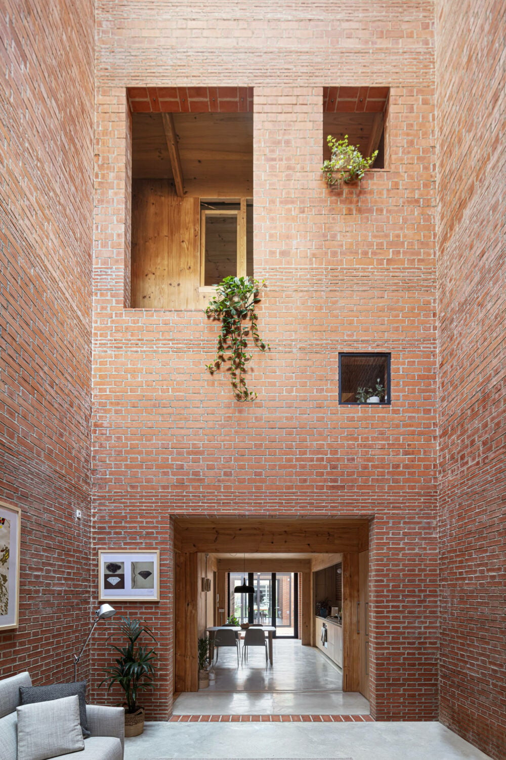 Im Inneren des Gebäudes wird man von einem 14,6 Meter hohen Raum empfangen, der durch das gesamte Erdgeschoss bis in zum Garten blicken lässt. Hinter einer Art zweiter Fassade liegen die Schlafzimmer.