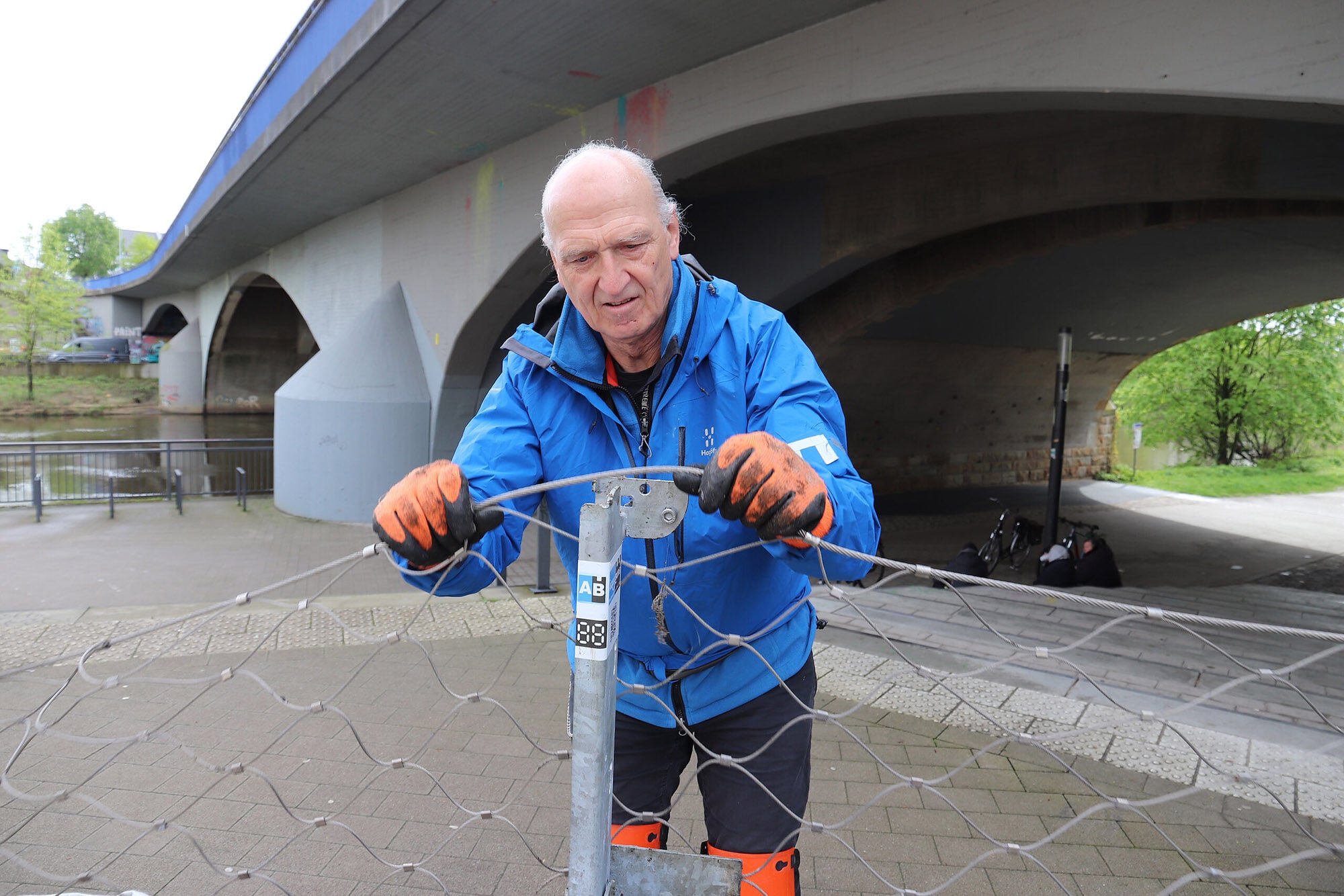 Das Stahlnetz wird anschließend in die Pfosten eingehängt