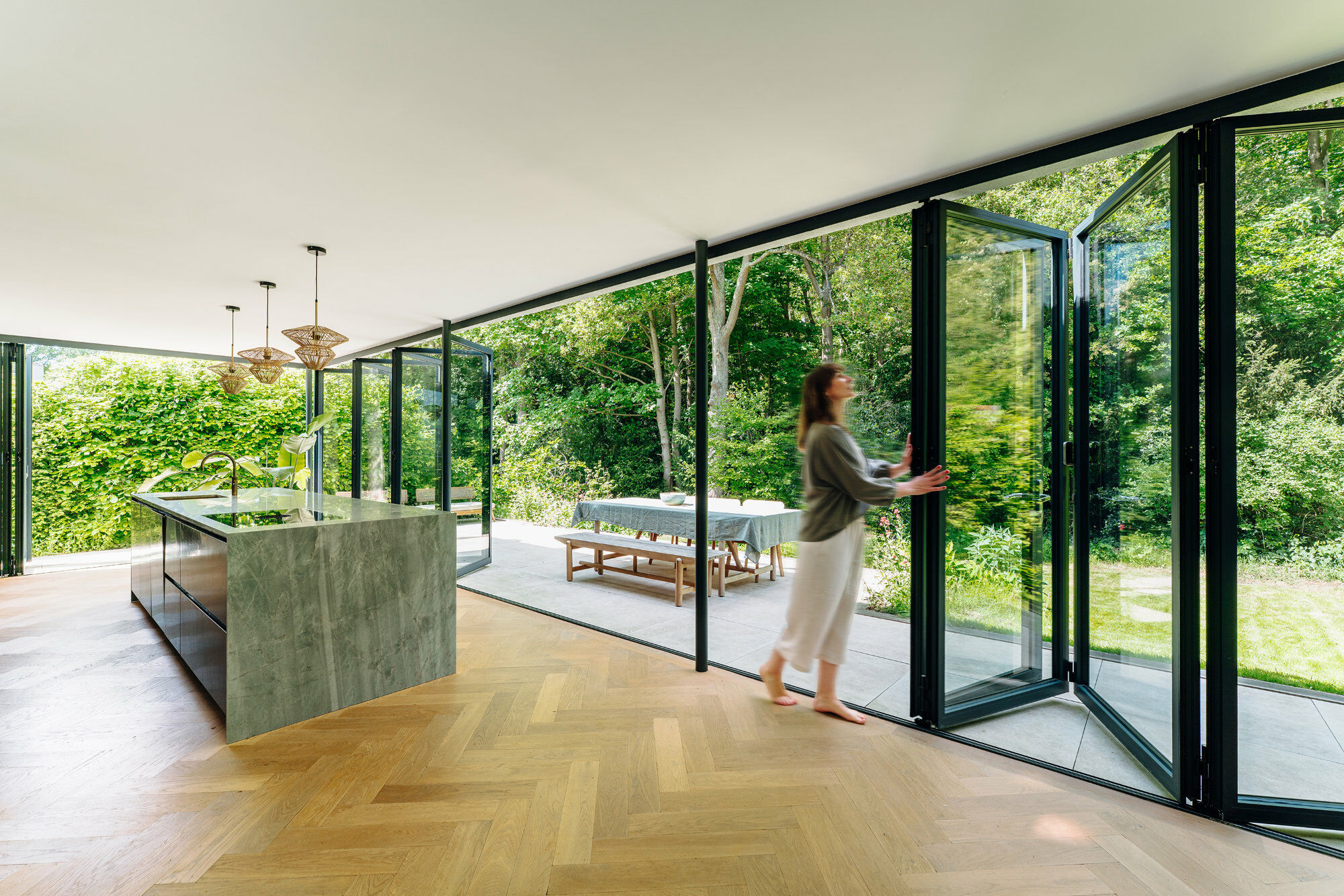 Die Offenheit der ineinander übergehenden Nutzungszonen wird durch die terrassenseitigen Glas-Faltwände verstärkt.