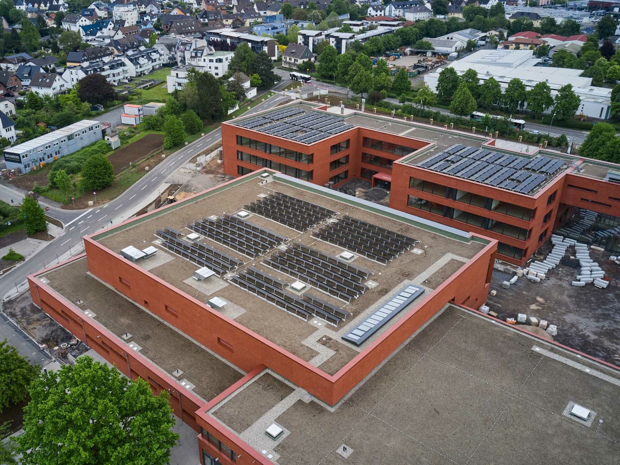 In Niederkassel erhielt das Schulzentrum Nord 2026 eine Mehrzweckhalle mit Mensa (im Bild vorne) und ein neues Unterrichtsgebäude (im Bild hinten), beide geplant von Fischer + Fischer Architekten und HKS Architekten.