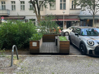 Begrünte Parklets sind Instrumente der Klimaanpassung, die das Mikroklima verbessern und urbanen Hitzeinseln entgegenwirken.
