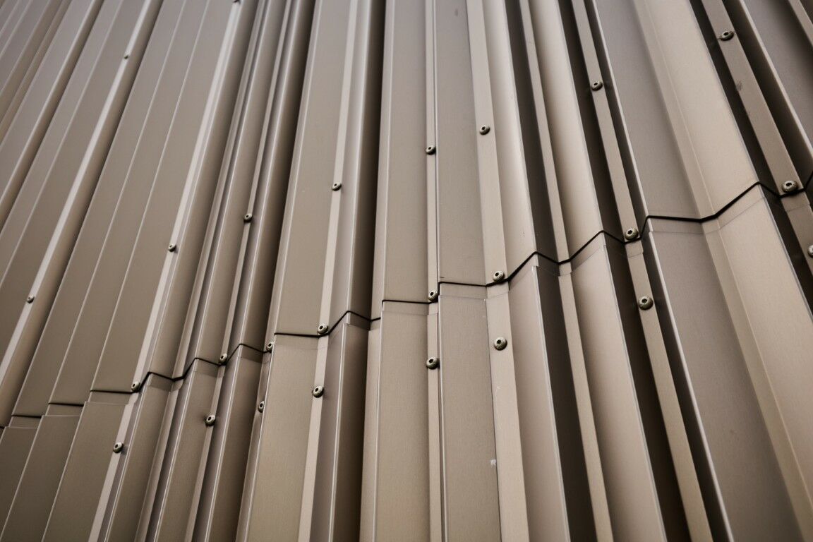 Hinter der vorgehängten hinterlüfteten Fassade aus gekanteten Aluminiumblechen befindet sich eine Mineralwolldämmung.