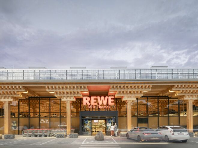 Der REWE Green Farming Markt in Berlin-Lankwitz hat ein sichtbares Tragwerk aus Holz und Gewächshäuser auf dem Dach.