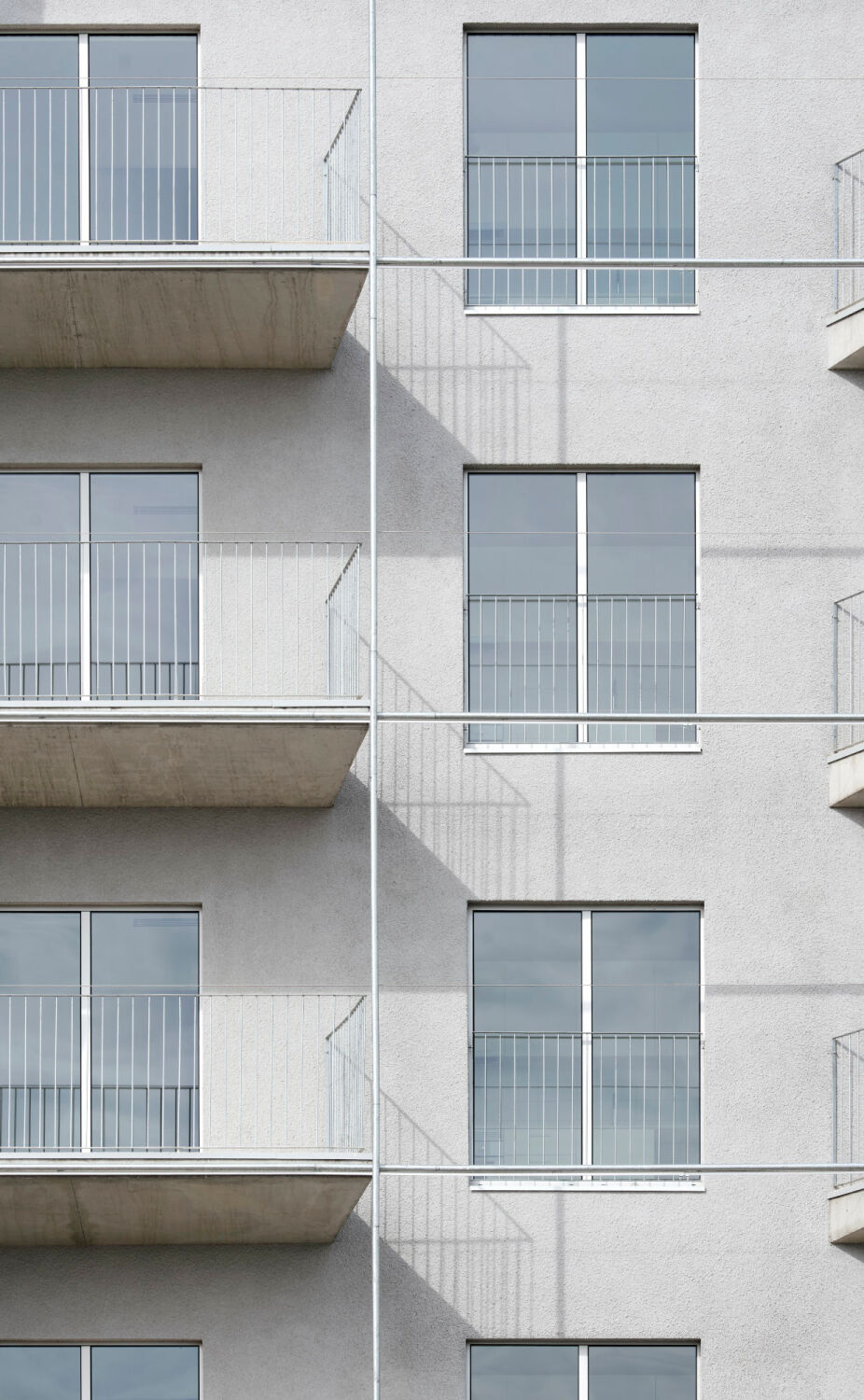 Regelmäßig angeordnete Fenster und Balkontüren sorgen für eine klare, ruhige Struktur.