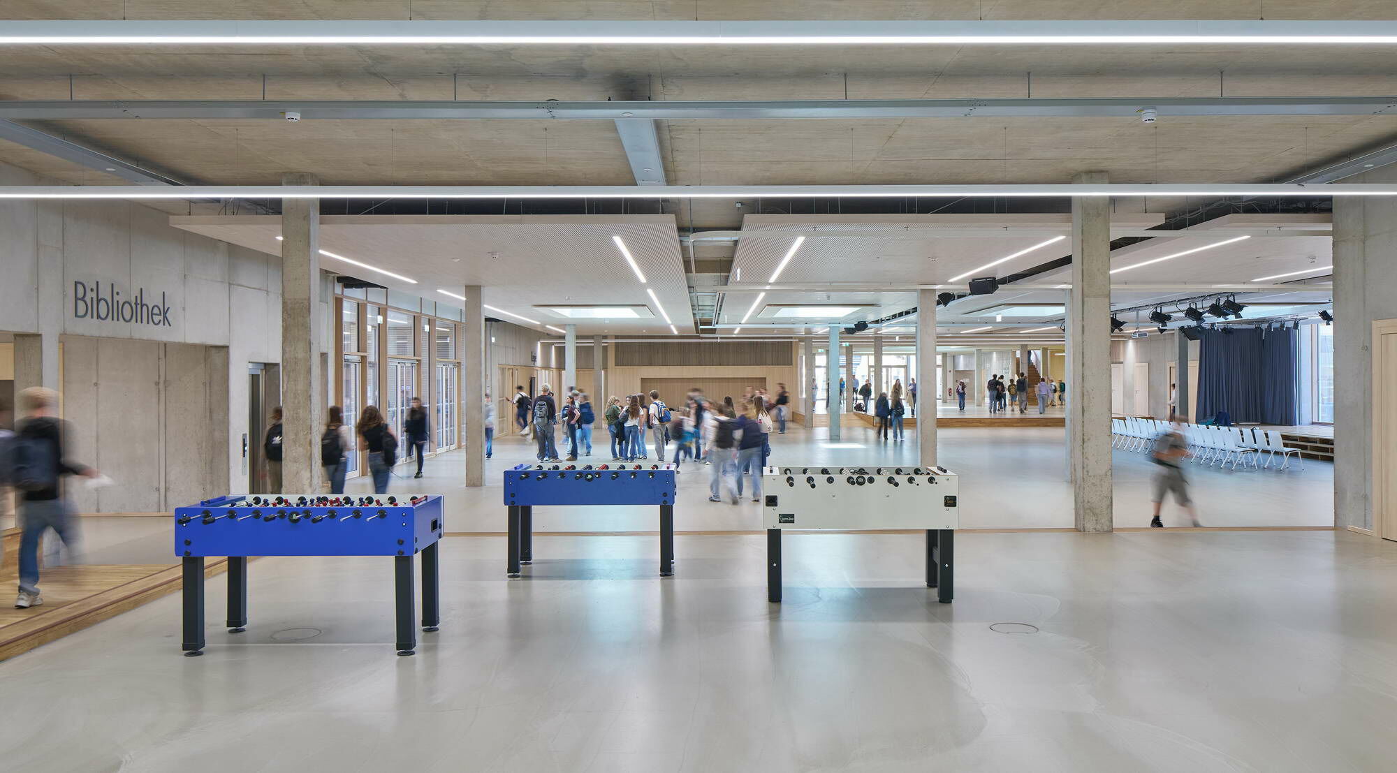 Im Erdgeschoss befinden sich die schulöffentlichen Bereiche mit offenen Nutzungsangeboten und unterschiedlichen Aufenthaltsmöglichkeiten: die variabel bespielbare Aula, Pausenhallen, Garderoben, Räume für die Schulorganisation, Bibliothek und Mensa.