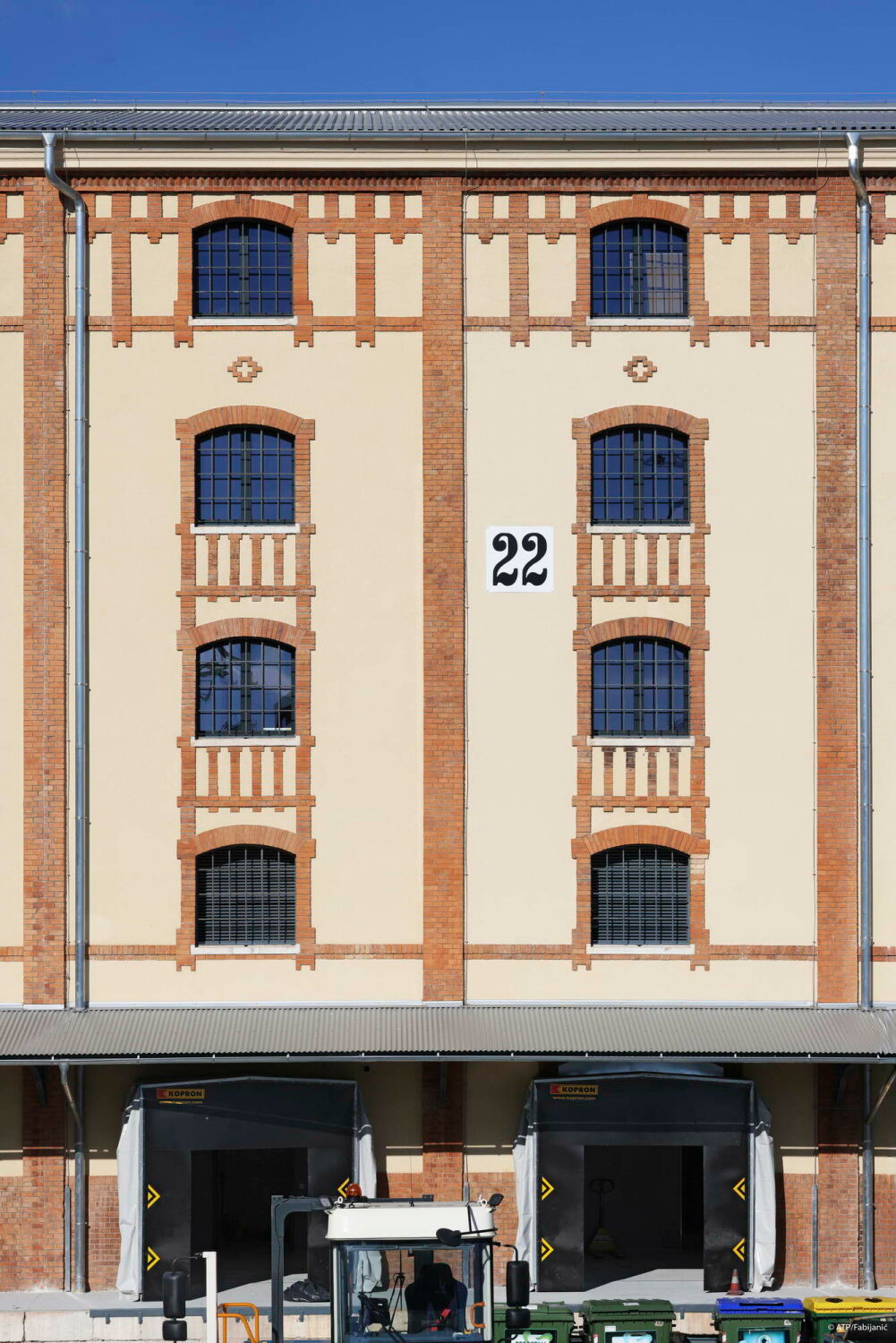 Das Ziegelmauerwerk der historischen Fassade rahmt die Gitterglasfenster, die vertikale Gliederung wird durch Pilaster betont.