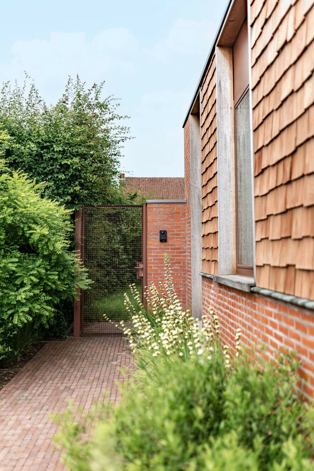 Die Außenhaut besteht im oberen Bereich aus einer Verkleidung mit Zedernholzschindeln, die vor Witterungseinflüssen schützt. Im bodennahen Bereich errichtete man als Spritzwasserschutz einen Sockel aus recycelten Ziegelsteinen. 