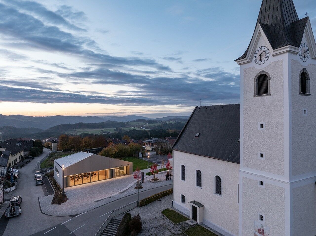 Zwischen Kirche, Gemeindeverwaltung und Konditorei ergänzt der Neubau die bestehende dörfliche Infrastruktur.
