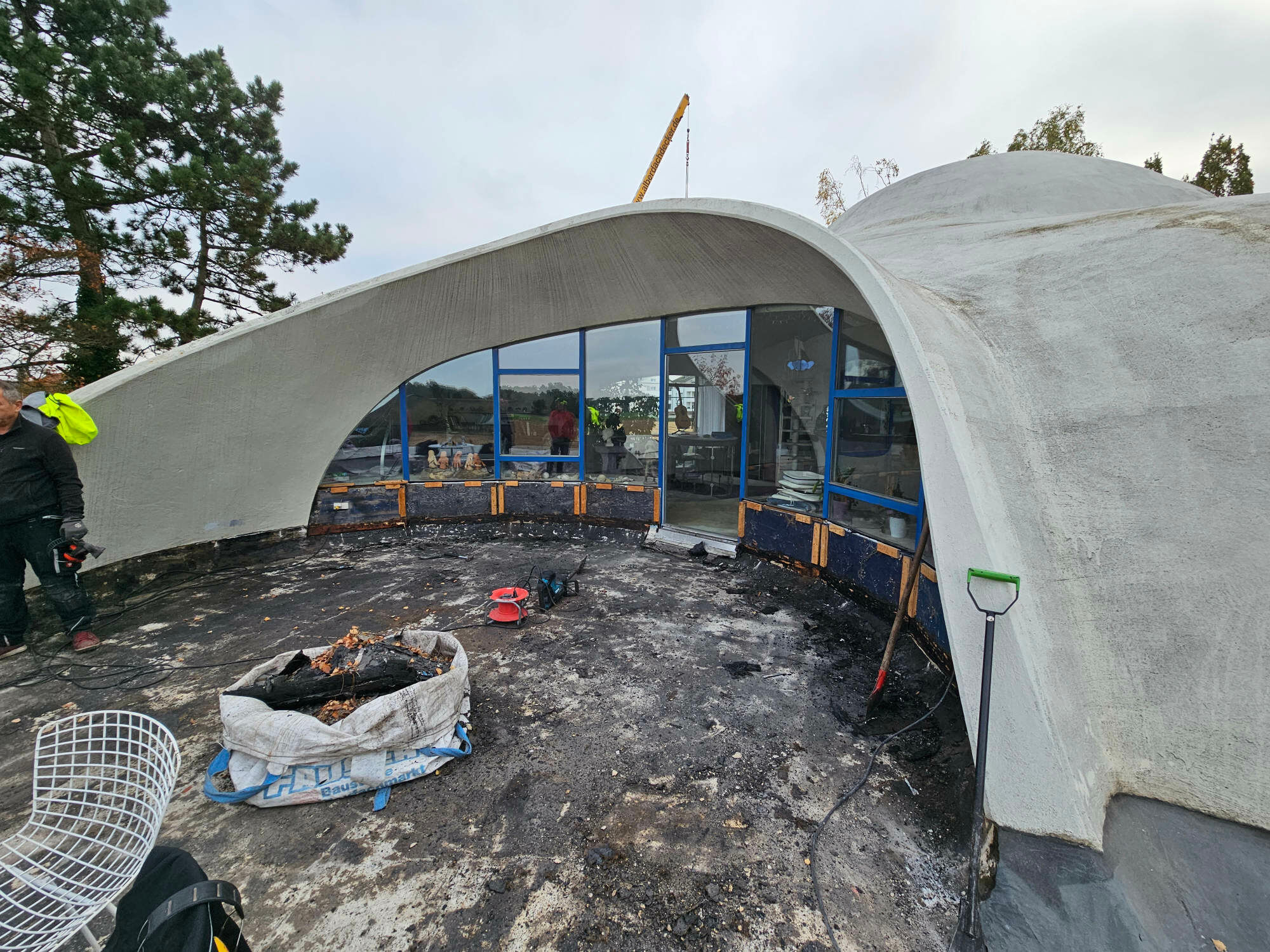 Auf dem sogenannten Terrassenteller treffen unterschiedlich gekrümmte Betonflächen auf die großflächige Verglasung des Wohngeschosses.