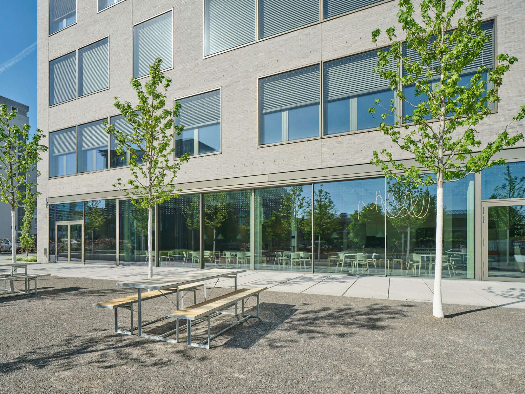 Regelmäßig angeordnete, großzügige Fensteröffnungen gliedern die Mauerwerksfassade horizontal.