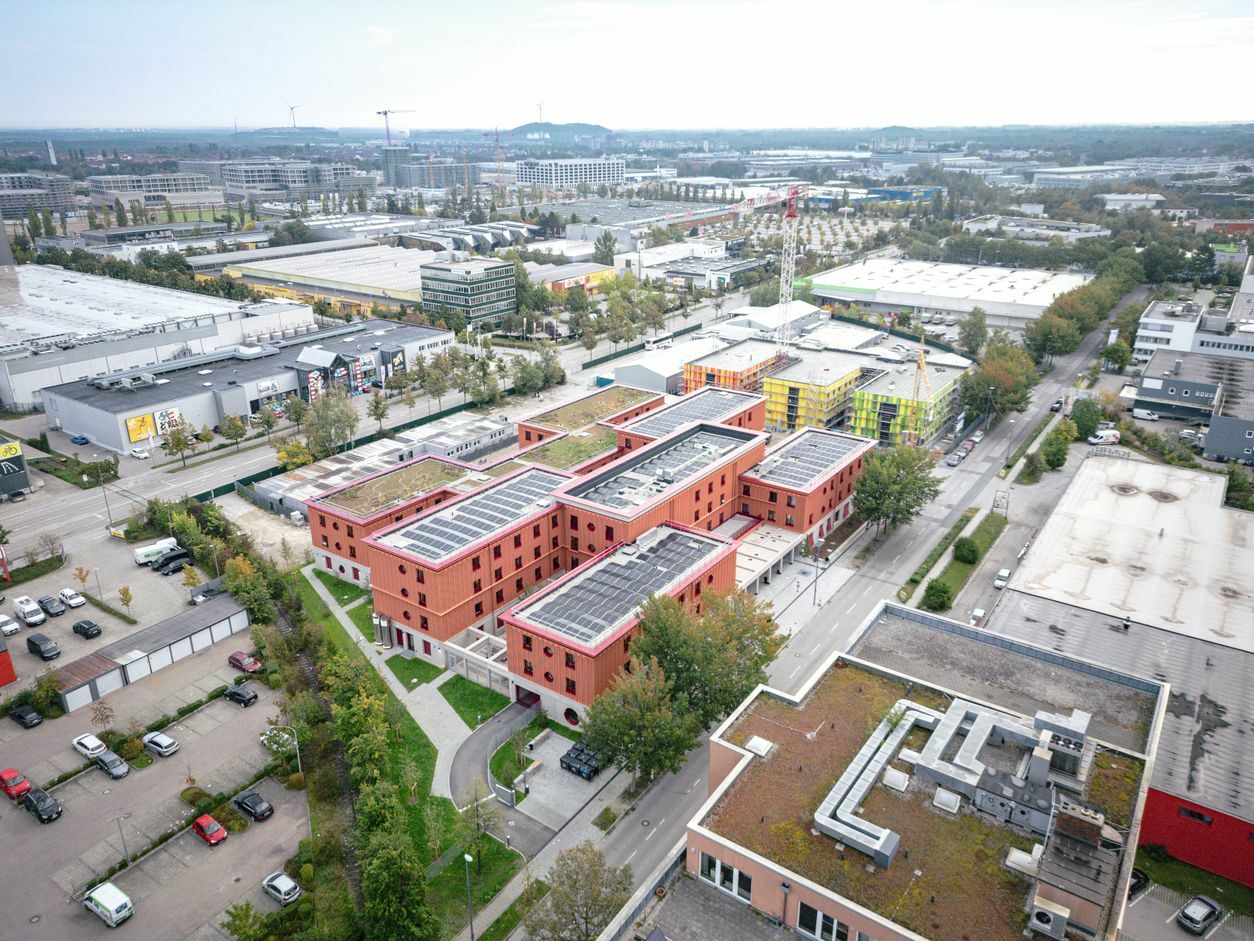 Hild und K Architekten entwarfen ein Ensemble aus versetzt angeordneten Gebäuderiegeln, welche in den Eckbereichen verbunden sind.