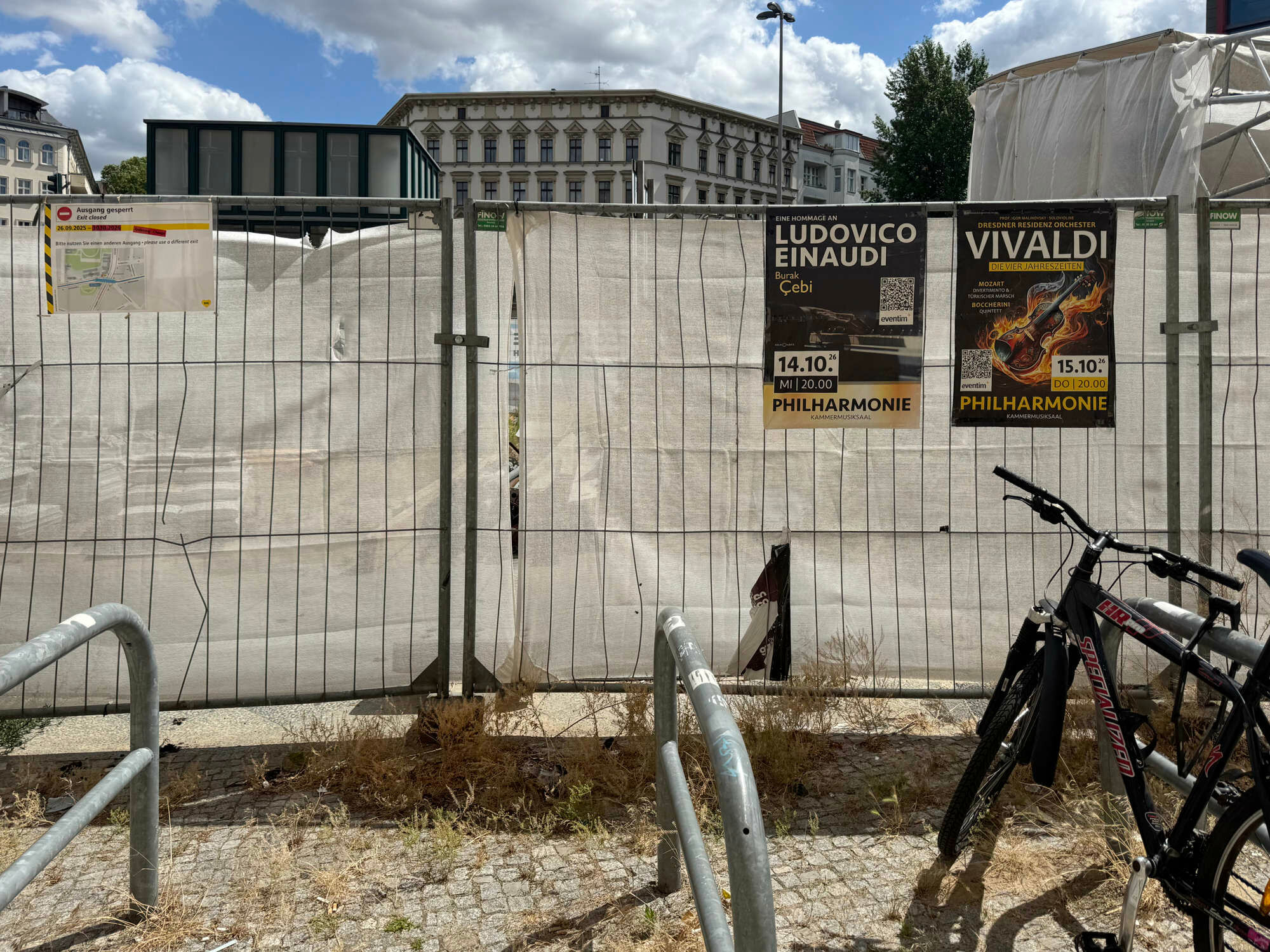Bauzaun mit Plane, Werbeplakaten und Infotafel zur Verlegung einer ÖPNV-Haltestelle