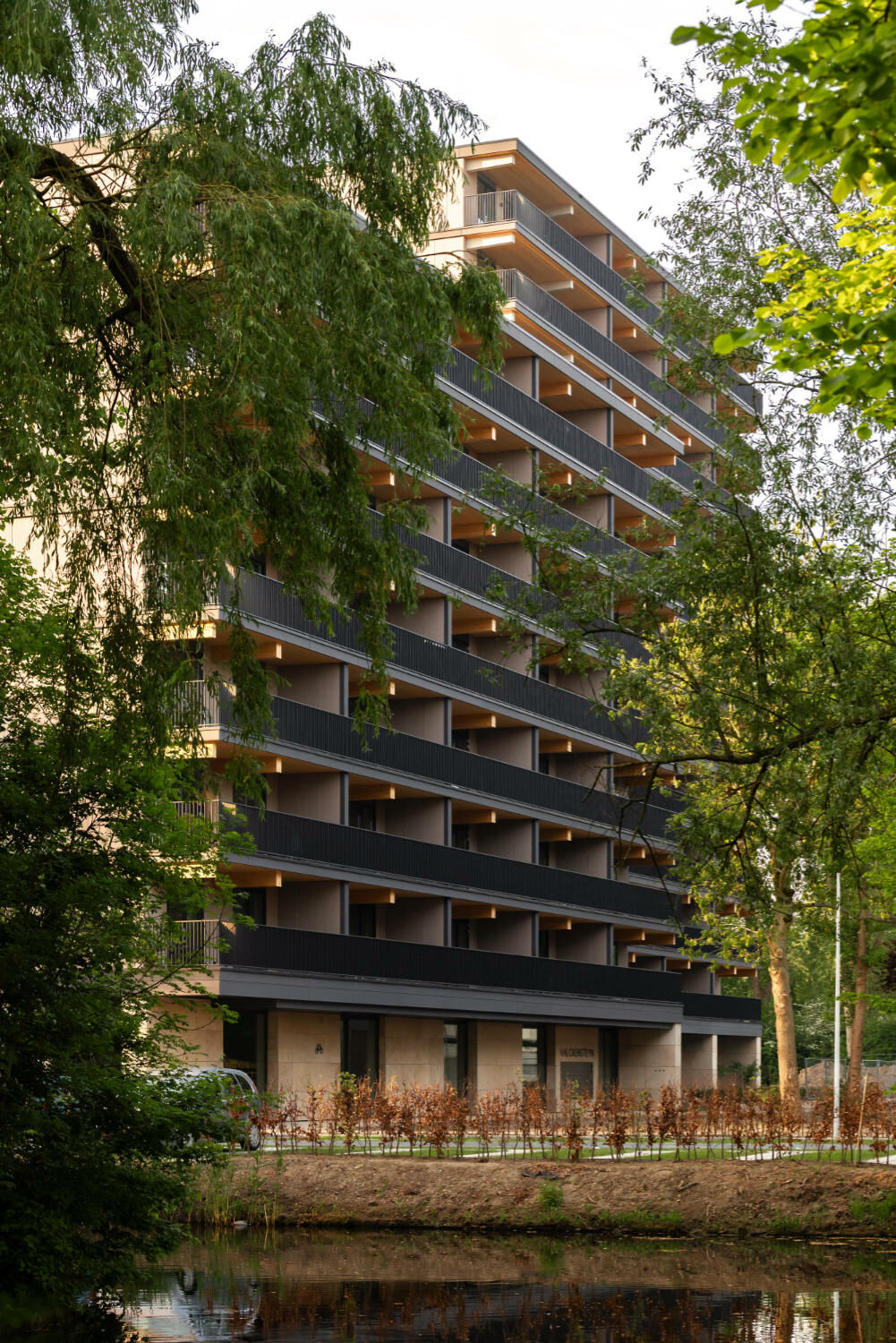 Während der Sockel mit historisierendem Travertin verkleidet ist, schützen in den Obergeschossen demontierbare Faserzementplatten in Anthrazit- und Brauntönen das Holz vor der Witterung. 