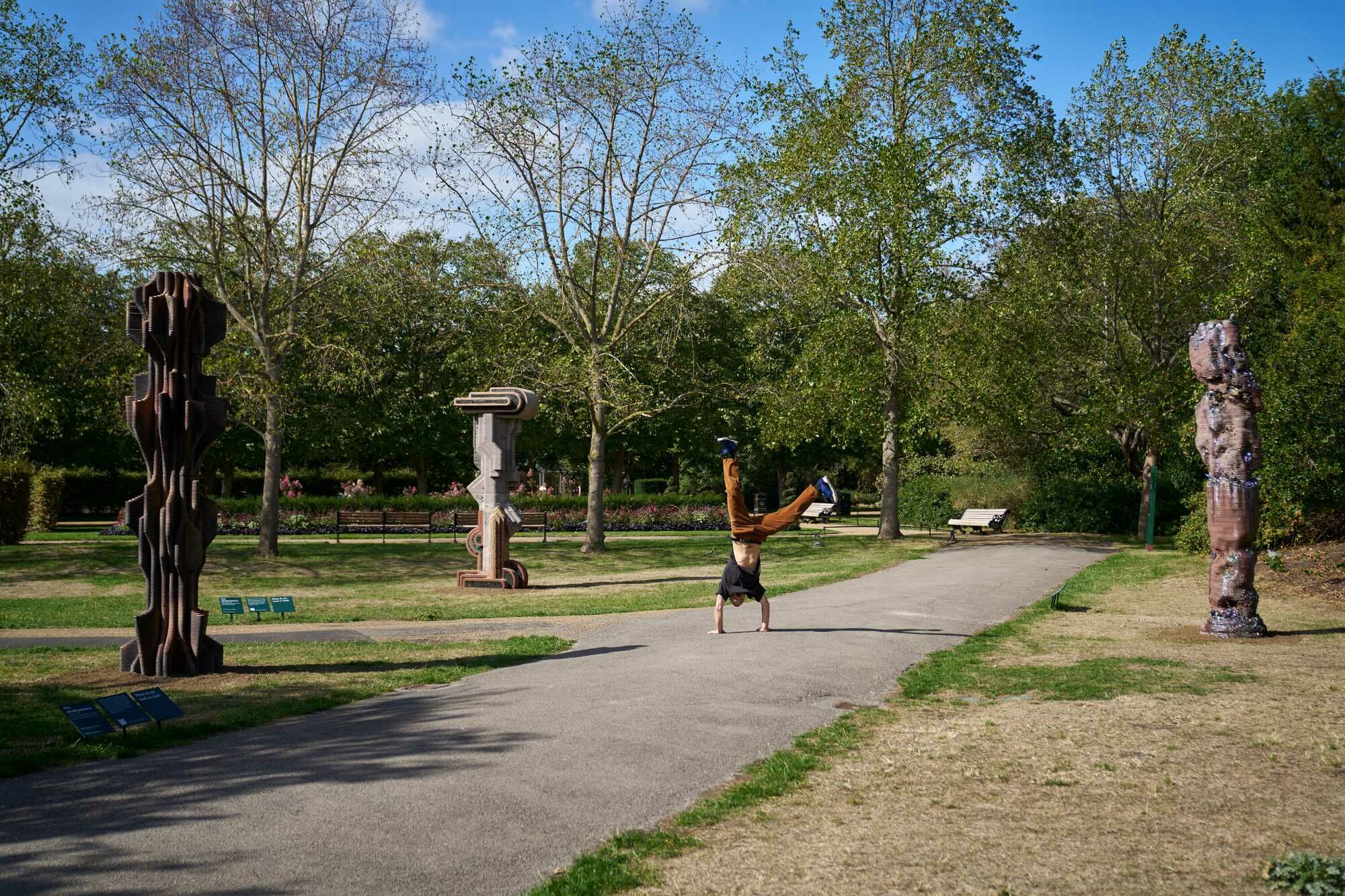 Die monumentalen Skulpturen stehen zwischen Bäumen und Spazierwegen der English Gardens.