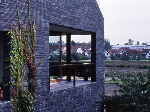 Wohnhaus in Kaufbeuren von Kehrbaumarchitekten, Augsburg: Die Fassaden schließen mit einer 10/30 mm Natursteinverblendung aus Schiefer in freier Länge ab.