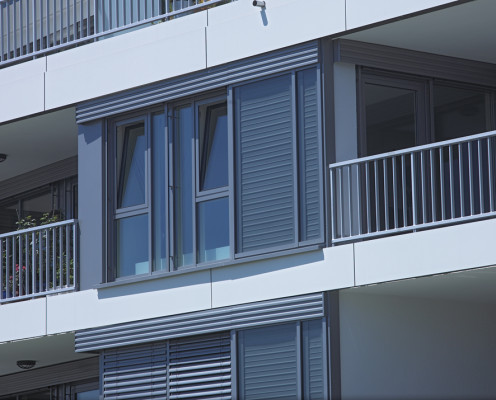 Rechts der Fenster die solarthermische Warmwasserkollektoren, links die schmale, blickdichte Verblendung, oben der außenliegende Sonnenschutz