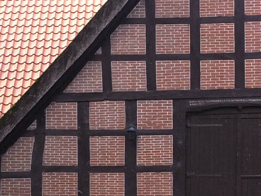 Umgenutztes Bauernhaus in Niedersachsen: Waagrechte und senkrechte Holzstreben bilden das Tragwerk, die dadurch entstandenen Zwischenräume werden Gefache genannt.