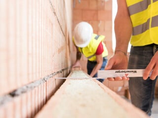 Der Wärmetransport infolge Wärmeleitung durch ein Bauteil wird durch die Dicke und die Wärmeleitfähigkeit der einzelnen Bauteilschichten beeinflusst, im Bild eine zweischalige Wand aus mit Mineralwolle verfüllten Ziegeln.