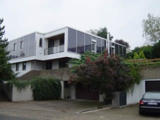Straßenansicht des Hanghauses. Im Untergeschoss erlaubte die Anwendung von dünner Vakuum-Isolierung eine knappe Detailausbildung, die dem Baukörper auch optisch zu Gute kommt.