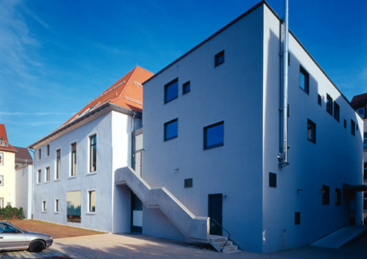 Bühnenneubau aus Stahlbaton im Rücken des alten Saalgebäudes. Der schwierigste Eingriff in den Bestand war der 10 m breite Durchbruch im Bruchsteinmauerwerk der ehemaligen Außenwand als Verbindung zum Saal. 