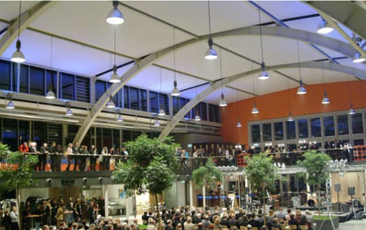 Das Tragwerk der weitgespannten Stahlbögen wurde freigelegt. Eine zweite Ebene oberhalb der ehemaligen Sportfläche steht als Galerie für zusätzliche Nutzungen offen.