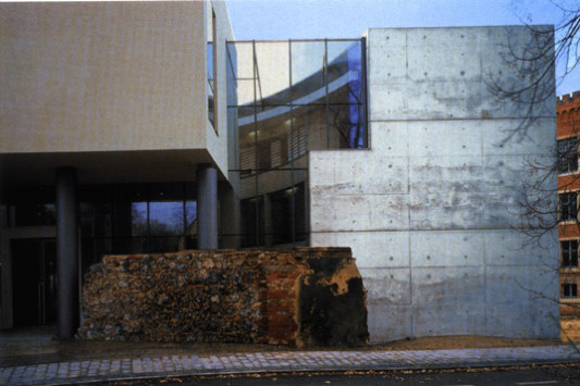 Die Mauerreste des alten Komplexes blieben als Reminiszenz an den ehemaligen Burghof erhalten. Unter den aufgeständerten Gerichtssälen führt der Straßenbelag in das verglaste Atrium des neuen Zivilgerichts.