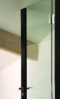 Raumhohe Innentür aus Glas mit schwarzen Rahmenfriesen