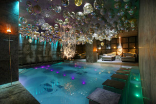 Mit Glaskugeln dekorierter Hotelpool in farbigem Licht 