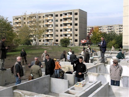 Künstlerischer Kommentar in Beton-Ästhetik: Im  Hintergrund ein für den Rückbau vorbereiteter  P2-Plattenbau