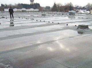 Sanierungsfall Flachdach, erzeugt durch stehendes Wasser und undichte Gullys